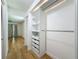 Walk-in closet with custom shelves and drawers, bamboo floors and bedroom access at 13891 Feather Sound Dr, Clearwater, FL 33762