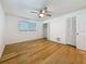Bright bedroom featuring a ceiling fan, wood floors, and closet with louvered doors at 13891 Feather Sound Dr, Clearwater, FL 33762
