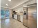Modern kitchen boasts stainless steel appliances, white cabinets, and a door leading to outdoor patio at 13891 Feather Sound Dr, Clearwater, FL 33762