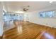 Open living room with hardwood floors and view to the kitchen and front entrance at 13891 Feather Sound Dr, Clearwater, FL 33762