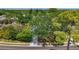 Street-view perspective of a property with large trees, offering shade and curb appeal at 13891 Feather Sound Dr, Clearwater, FL 33762
