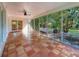 Bright sunroom with tile floors and large glass windows offering views of the lush backyard at 13891 Feather Sound Dr, Clearwater, FL 33762