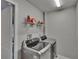 Laundry room with modern stainless steel front load washer and dryer plus storage shelves at 1406 Bloomingdale Trails Blvd, Brandon, FL 33511