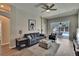 Cozy living room featuring a gray sofa, plush ottoman, and view of the outdoor pool area at 1406 Bloomingdale Trails Blvd, Brandon, FL 33511
