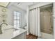 Neutral bathroom with laminate floors, shower/tub combination, and sink with white countertop at 14078 Leeward Dr, Seminole, FL 33776