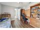 Neutral bedroom with laminate floors, an adjacent bathroom, and wooden shelving at 14078 Leeward Dr, Seminole, FL 33776
