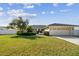 Charming single-story home with a well-manicured lawn, mature trees, and a two-car garage at 14078 Leeward Dr, Seminole, FL 33776