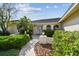 Inviting front entrance with double doors, arched windows, and lush landscaping around the walkway at 14078 Leeward Dr, Seminole, FL 33776