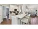 Open kitchen with white cabinets, stainless steel appliances, breakfast bar, and wood flooring at 14078 Leeward Dr, Seminole, FL 33776