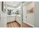 Bright bathroom with white cabinets, dual sinks, and a sliding glass door closet at 14078 Leeward Dr, Seminole, FL 33776