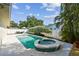 Private pool with spa, surrounded by a white fence, and lush tropical landscaping at 14078 Leeward Dr, Seminole, FL 33776