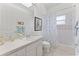 Clean bathroom featuring a white vanity, toilet, shower with curtain, and tile flooring at 15703 Walden Ave, Tampa, FL 33618
