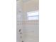 Bright bathroom featuring a bathtub with white tile surround and a window allowing natural light at 15703 Walden Ave, Tampa, FL 33618