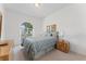 Cozy bedroom featuring a bed with blue patterned bedding, arched window, and wood furniture at 15703 Walden Ave, Tampa, FL 33618
