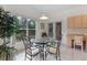 Light-filled breakfast nook with a glass table and views of the lush landscaping at 15703 Walden Ave, Tampa, FL 33618