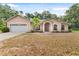 Inviting single-story home with arched entryway, two-car garage and mature landscaping at 15703 Walden Ave, Tampa, FL 33618