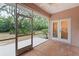 Enclosed patio with brick flooring, a ceiling fan, and views of the lush backyard at 15703 Walden Ave, Tampa, FL 33618