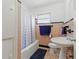 Full bathroom with pink tiling, classic fixtures and a window for natural light at 1610 15Th N St, St Petersburg, FL 33704