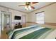 Well-lit bedroom offers wood floors, ceiling fan, and a view into the hallway at 1610 15Th N St, St Petersburg, FL 33704