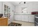Bright kitchen features white cabinets, retro tile flooring, and door access to outdoor at 1610 15Th N St, St Petersburg, FL 33704