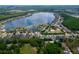 Aerial shot showcasing a serene lake surrounded by lush greenery and homes in a well-planned community at 16113 Rambling Rd, Odessa, FL 33556