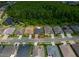 Aerial view of a property surrounded by lush greenery, a pond, and neighboring homes in a well-kept community at 16113 Rambling Rd, Odessa, FL 33556