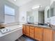 This bathroom has a soaking tub, granite counters, and a double sink vanity at 16113 Rambling Rd, Odessa, FL 33556