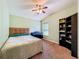 The bedroom has carpet, a bookcase, a piano, and a ceiling fan at 16113 Rambling Rd, Odessa, FL 33556