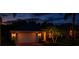 Charming single-story home with a two-car garage, red brick driveway and manicured lawn at night at 16113 Rambling Rd, Odessa, FL 33556