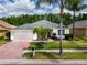 Well-maintained single-story home with a two-car garage, a red brick driveway and mature landscaping at 16113 Rambling Rd, Odessa, FL 33556