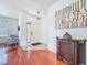 Inviting foyer with hardwood floors, a decorative pendant light, console table, and a view of the front door at 16113 Rambling Rd, Odessa, FL 33556
