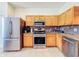 Functional kitchen with stainless steel appliances, wooden cabinets, tile floors and granite countertops at 16113 Rambling Rd, Odessa, FL 33556