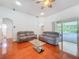 Relaxing living room features wood floors, neutral sofas, and sliding doors to a screened lanai for indoor-outdoor living at 16113 Rambling Rd, Odessa, FL 33556