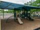 Playground featuring a green sun shade covering playground equipment including a slide and climbing area at 16113 Rambling Rd, Odessa, FL 33556