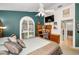 Comfortable bedroom featuring a ceiling fan, a study desk, and large arched window at 1647 Hamilton Ct, Dunedin, FL 34698