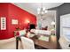 Dining area featuring a stylish table and chairs, accented by a bold red wall at 1647 Hamilton Ct, Dunedin, FL 34698