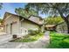 Exterior view showcases attached two car garage, mature trees, and beautiful landscaping at 1647 Hamilton Ct, Dunedin, FL 34698