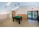 Bright game room features an old pool table, linoleum floors, wainscoting, and exit to a patio at 1647 Hamilton Ct, Dunedin, FL 34698