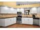 Modern kitchen with stainless steel appliances, white cabinets, and granite countertops at 1647 Hamilton Ct, Dunedin, FL 34698