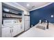 Charming kitchenette featuring open shelving, white cabinetry, stainless steel appliances, and marble countertops at 1647 Hamilton Ct, Dunedin, FL 34698