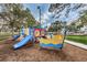 Colorful public playground equipment featuring slides, climbing structures, and a boat-shaped play area on a mulched surface at 1647 Hamilton Ct, Dunedin, FL 34698