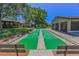 Community shuffleboard court view with benches and adjacent clubhouse on a sunny day at 1647 Hamilton Ct, Dunedin, FL 34698