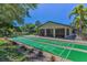 Community shuffleboard court with manicured landscaping, sidewalks, and adjacent clubhouse at 1647 Hamilton Ct, Dunedin, FL 34698