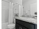 Bathroom with a shower-tub combo and black vanity with a gray countertop at 16633 Goose Ribbon Pl, Wimauma, FL 33598