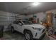 Attached garage with car, door openers and storage against the walls at 16633 Goose Ribbon Pl, Wimauma, FL 33598