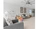 Bright living room features a neutral color palette, modern ceiling fan, and comfortable seating arrangement at 16633 Goose Ribbon Pl, Wimauma, FL 33598