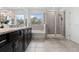 The main bathroom has double sinks, granite counters, a tub, and walk-in shower with glass doors at 16633 Goose Ribbon Pl, Wimauma, FL 33598