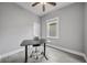 A simple bedroom with light grey walls features updated laminate flooring, a desk, and a window at 1708 E 15Th Ave, Tampa, FL 33605
