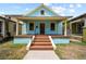 Charming blue home with inviting front porch and a few steps leading up to the door at 1708 E 15Th Ave, Tampa, FL 33605
