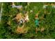 Aerial view of a secluded property nestled within a dense forest, featuring a private driveway and detached structure at 19266 Campground Rd, Brooksville, FL 34601